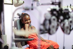 Child smiling in seat in doctor's office